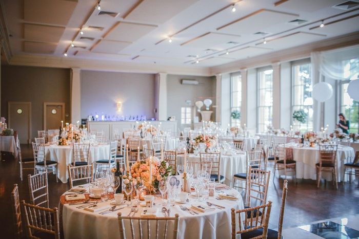 Bankettsaal mit runden Tischen und Blumengestecken
