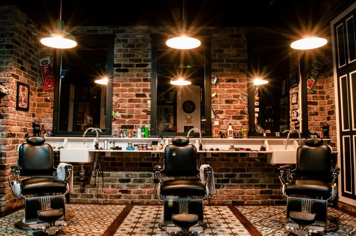 Leerer Barbershop mit Stühlen und Ziegelwänden