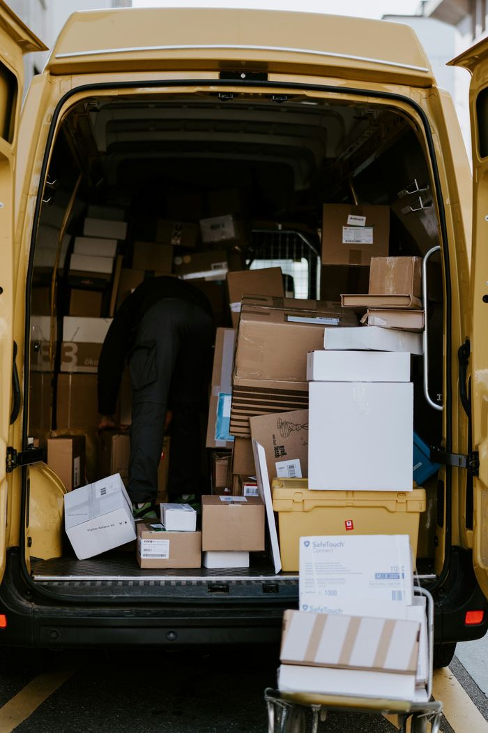 Estafeta a carregar caixas numa carrinha de entregas