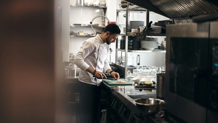 طاهٍ يحضّر الطعام في مطبخ احترافي