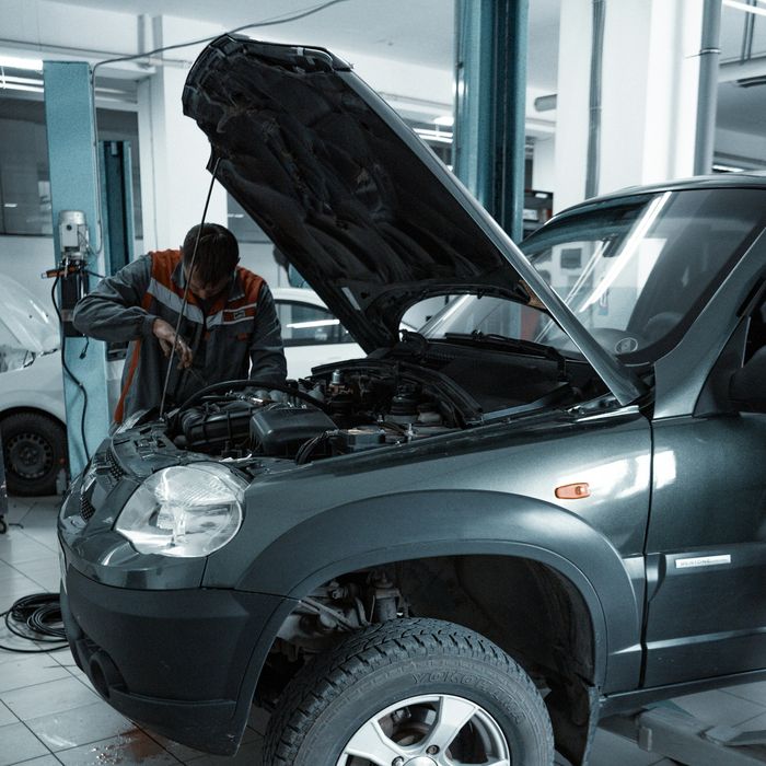 Mechaniker arbeitet unter der geöffneten Motorhaube