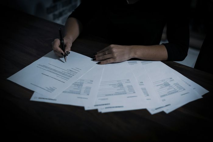 میز پر دستاویزات پر دستخط کرتے ہاتھ