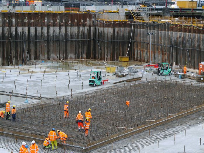 Baustelle mit Bewehrung und Team in Warnkleidung