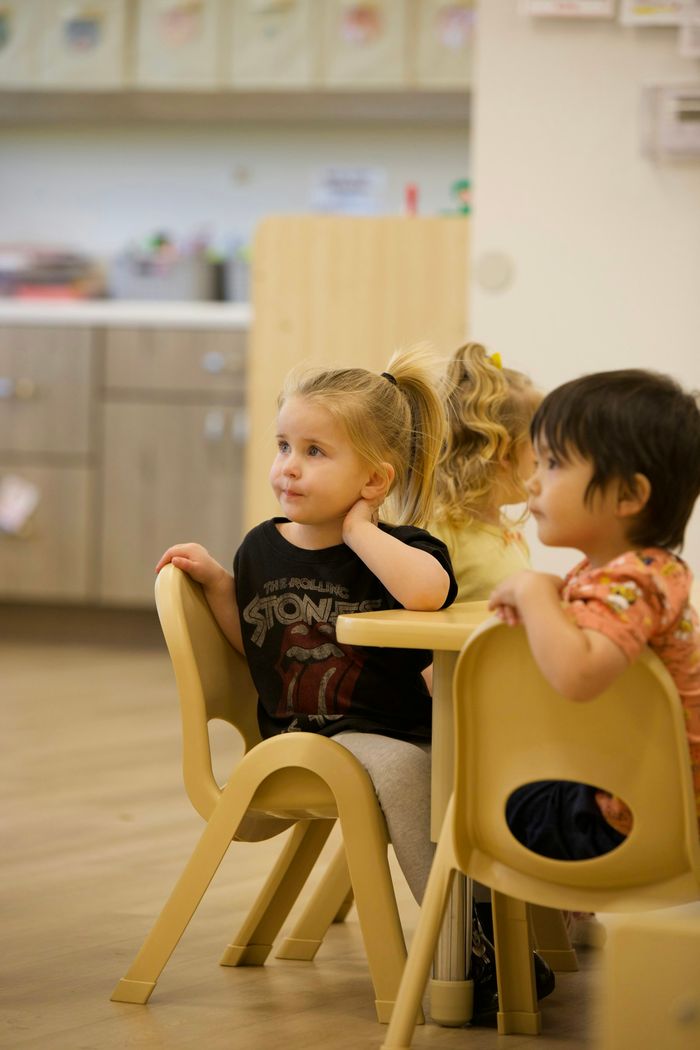 Kleinkinder sitzen an einem Tisch in der Kita